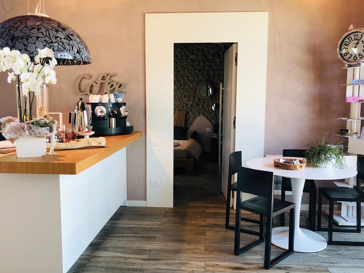 Angolo caffè e colazione con macchina Nespresso e insegna Coffee
